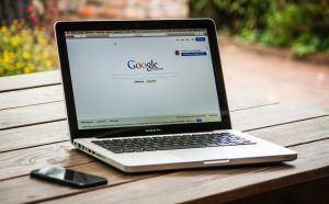 An open laptop on a table with Google home page displayed