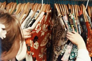 Hands searching through clothes on hangers