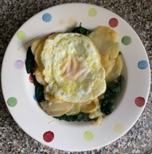 Plate of potatoes sliced with egg on top