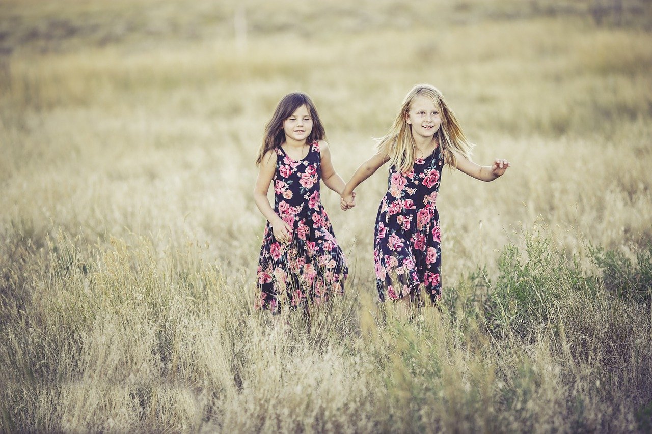 2 girls running through a field frugal fun