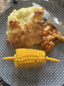 Mash potatoes and beans in a pie with corn on the cob side