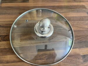 A glass and metal pan lid