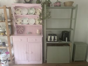 A painted pink dresser and green shelf unit