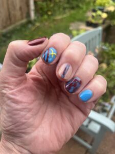 Nails painted in claret and blue