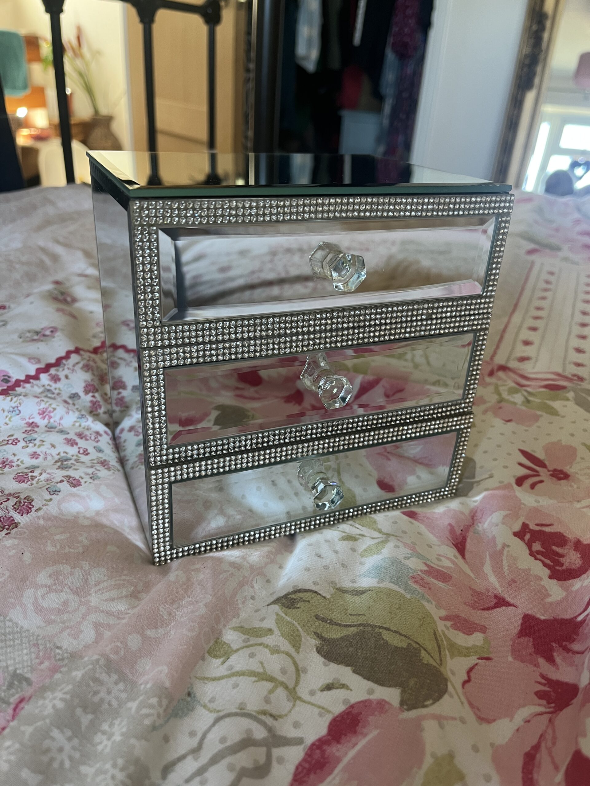 A small mirrored jewellery box with 3 drawers