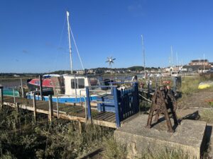 An old blue boat in the harbour with a clear blue sky behind