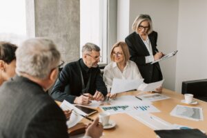Four smartly dressed people sitting looking at papers