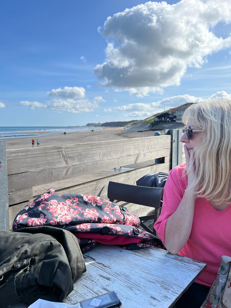 The author sitting at a table looking out to sea