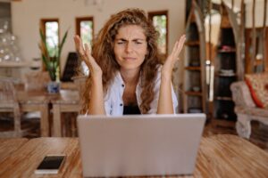 Woman looking frustrated in front of a laptop