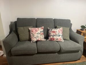 A green sofa with floral cushions