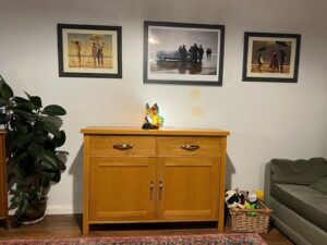 An oak sideboard with pictures above it