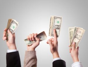 Hands clutching dollar bills