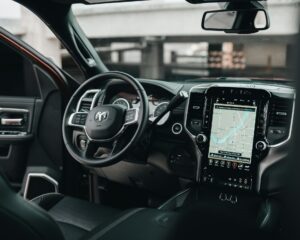 Inside of a car showing steering wheel and sat nav
