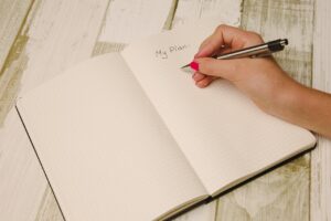 A hand writing in a notebook with the heading My Plan
