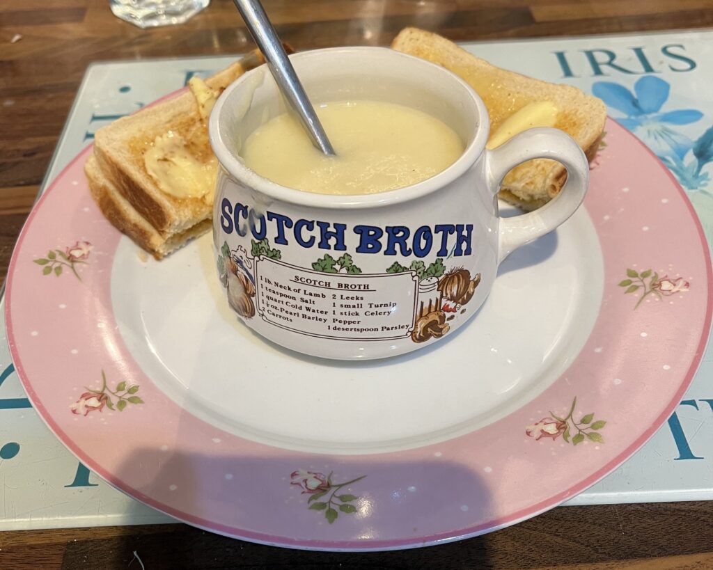 A bowl of soup on a plate of white toast
