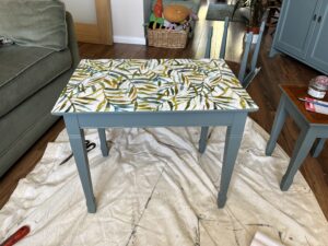 The same table painted green with a vinyl leaf print on the surface
