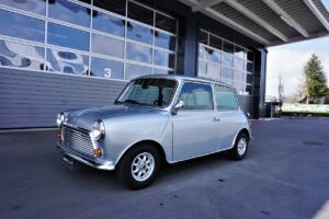 A silver Mini Cooper car parked in front of a warehouse