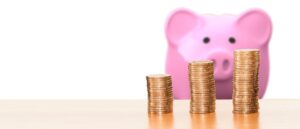 A piggy bank plus three piles of coins