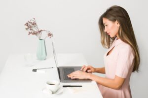 woman-in-pink-dress-using-laptop-computer