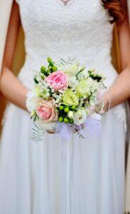 The body of a woman in a bridal gown holding a bouquet