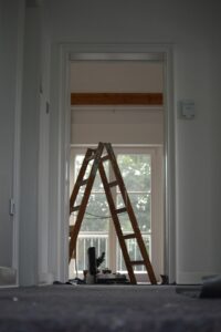 A stepladder in an empty room with a window behind