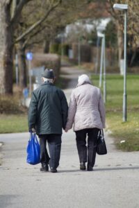 An older couple from behind walking hand in hand